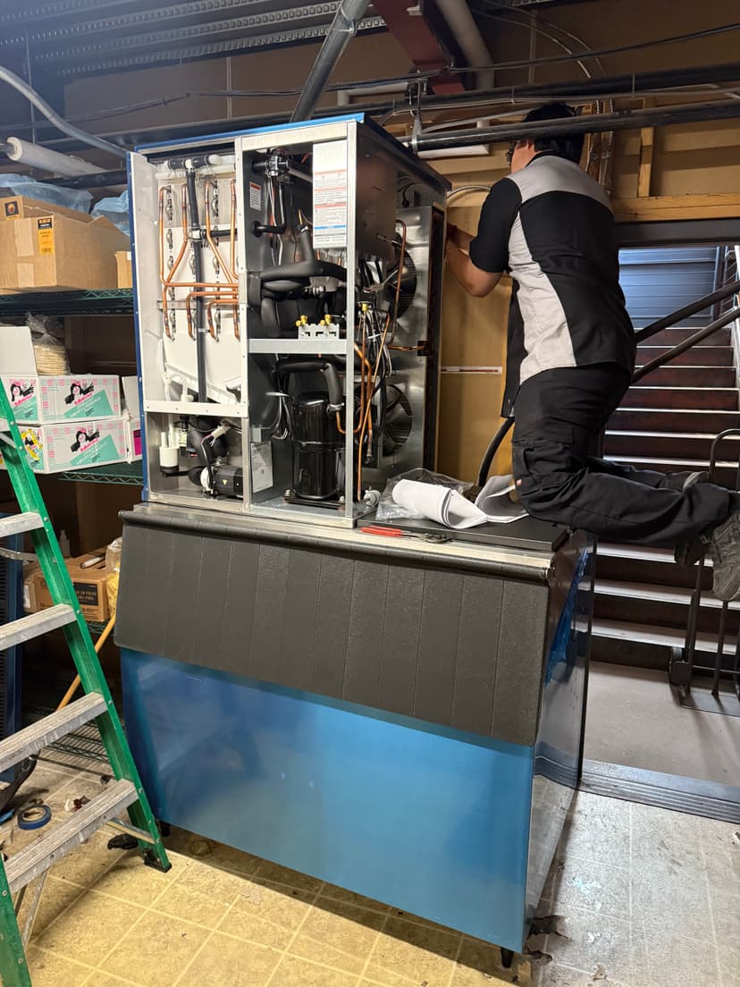 Technician repairing large commercial refrigeration unit