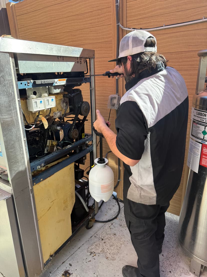 Technician performing preventive maintenance on equipment