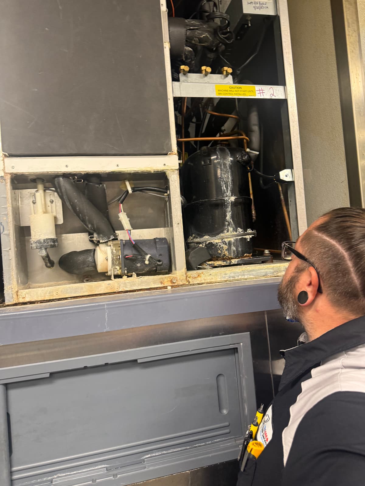 Eagle Repair technician inspecting refrigeration compressor